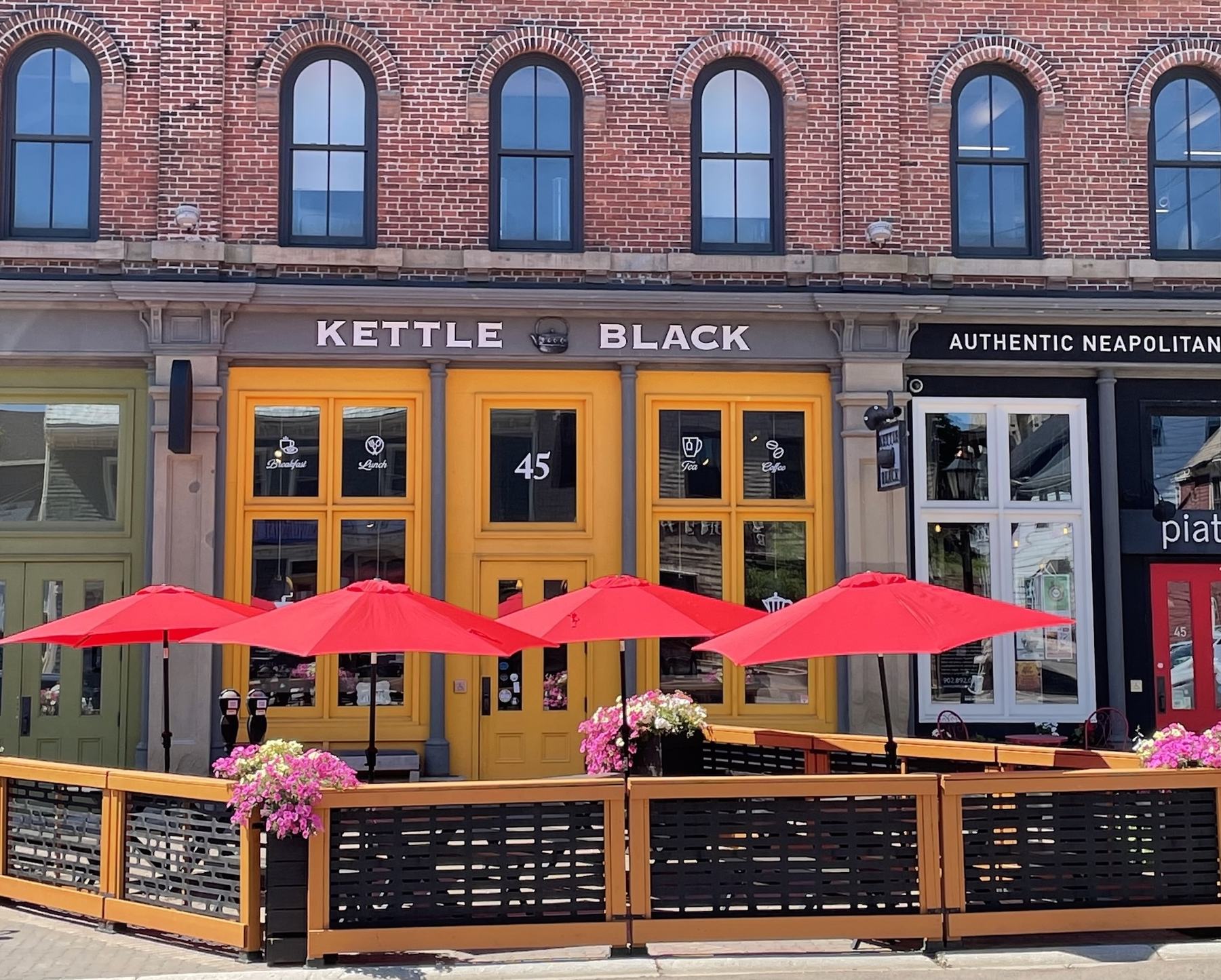 The Queen Street storefront with its yellow doors and red patio umbrellas
